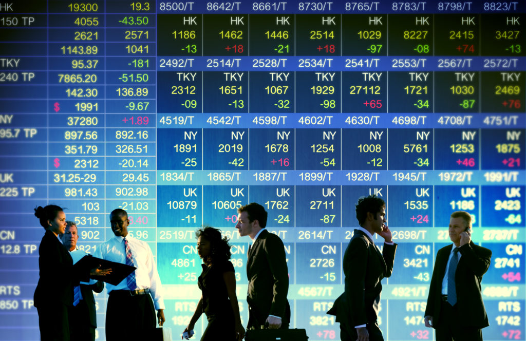 A diverse group of men and women stand in front of the New York Stock Exchange