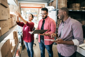 Featured image of two men and a woman looking at boxes stored in a warehouse