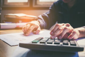 Feature image of a white man typing on a calculator